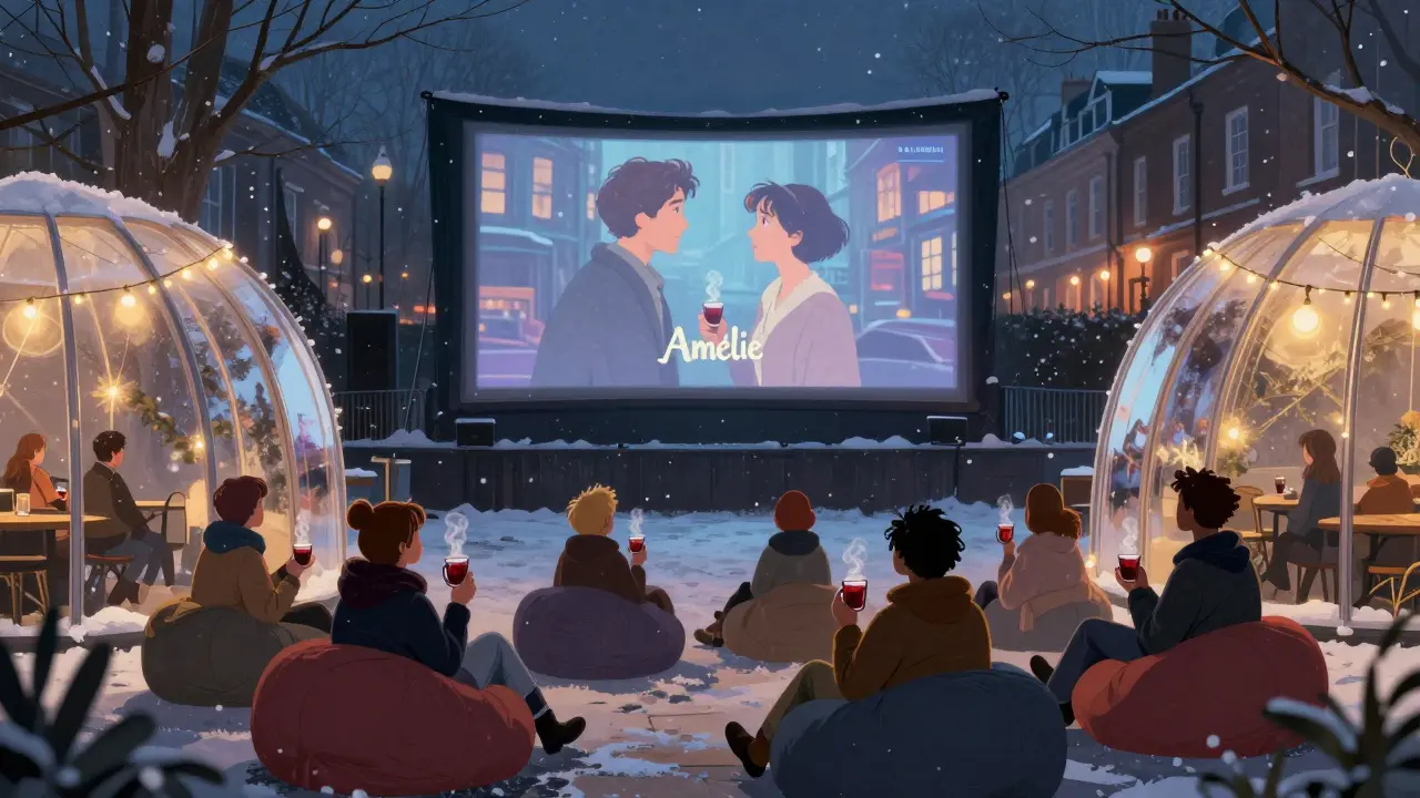People relaxing in heated domes under string lights, watching a film outdoors in winter snow.